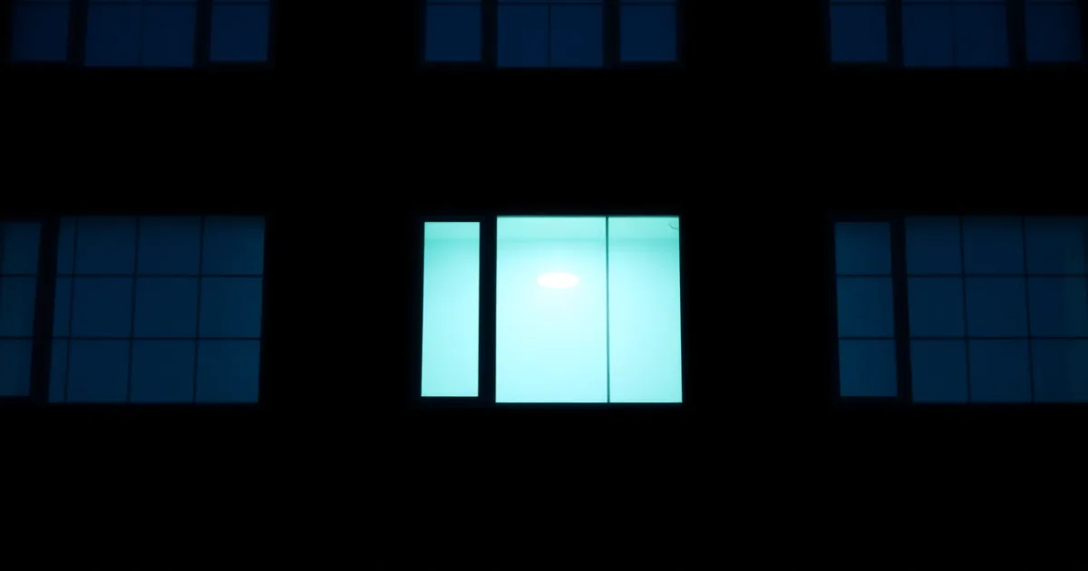 A dark facade of identical windows, a few lit from within, illustrating net CFC tested income and GILTI